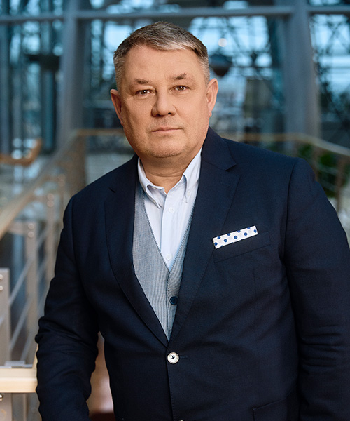 mężczyzna w garniturze na tle wnętrza nowoczesnej architektury