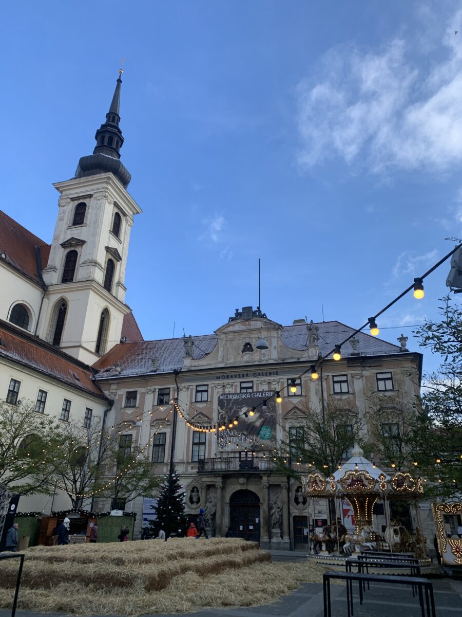 Wieża kościoła, wiszące lampki i jarmark świąteczny w Brnie