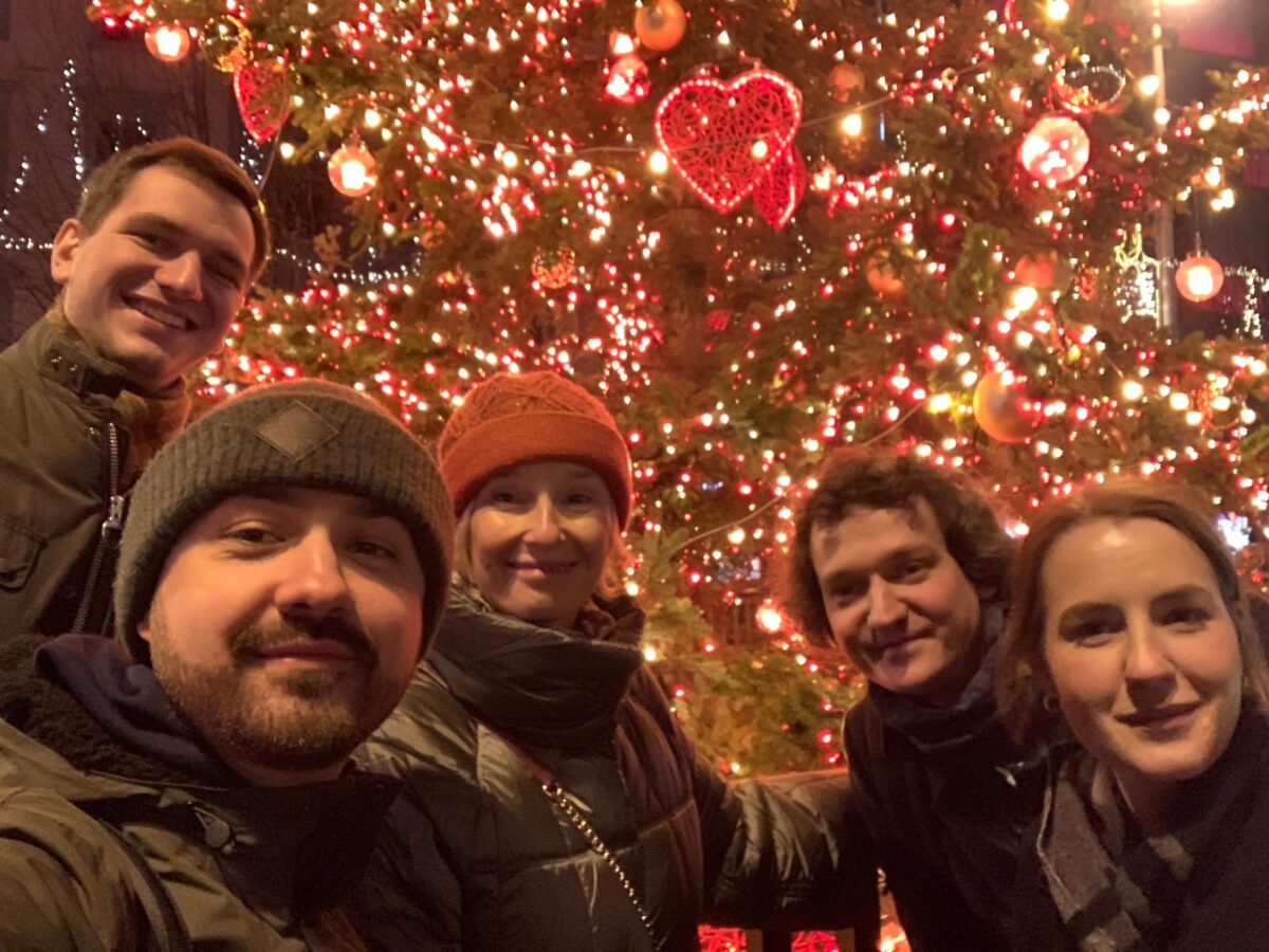 Zdjęcie na dworze, w tle choinka z lampkami, na pierwszym planie od lewej uśmiechnięci mgr Rzepiński, mgr Biernacki, prof. Klafkowska-Waśniowska, mgr Drąg, mgr Dzięgielewska