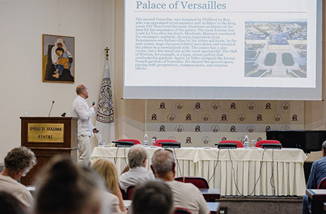 Mężczyzna prowadzi prezentację przed grupą słuchaczy w sali konferencyjnej